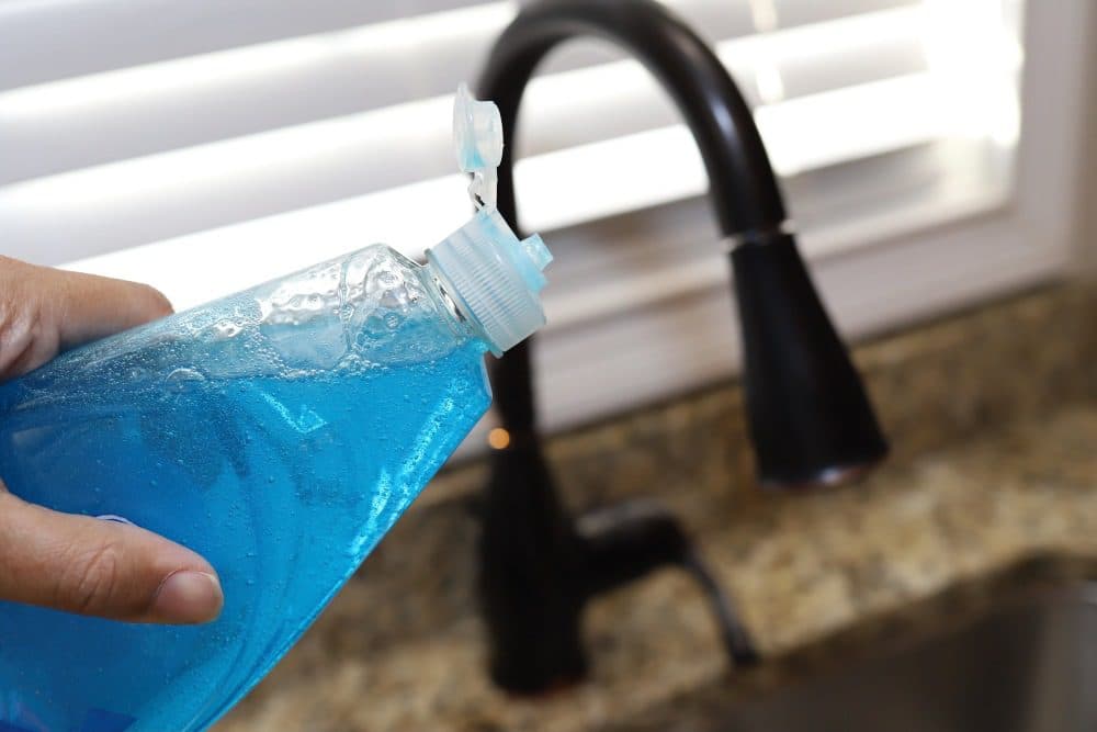 pouring dish soap down the kitchen sink