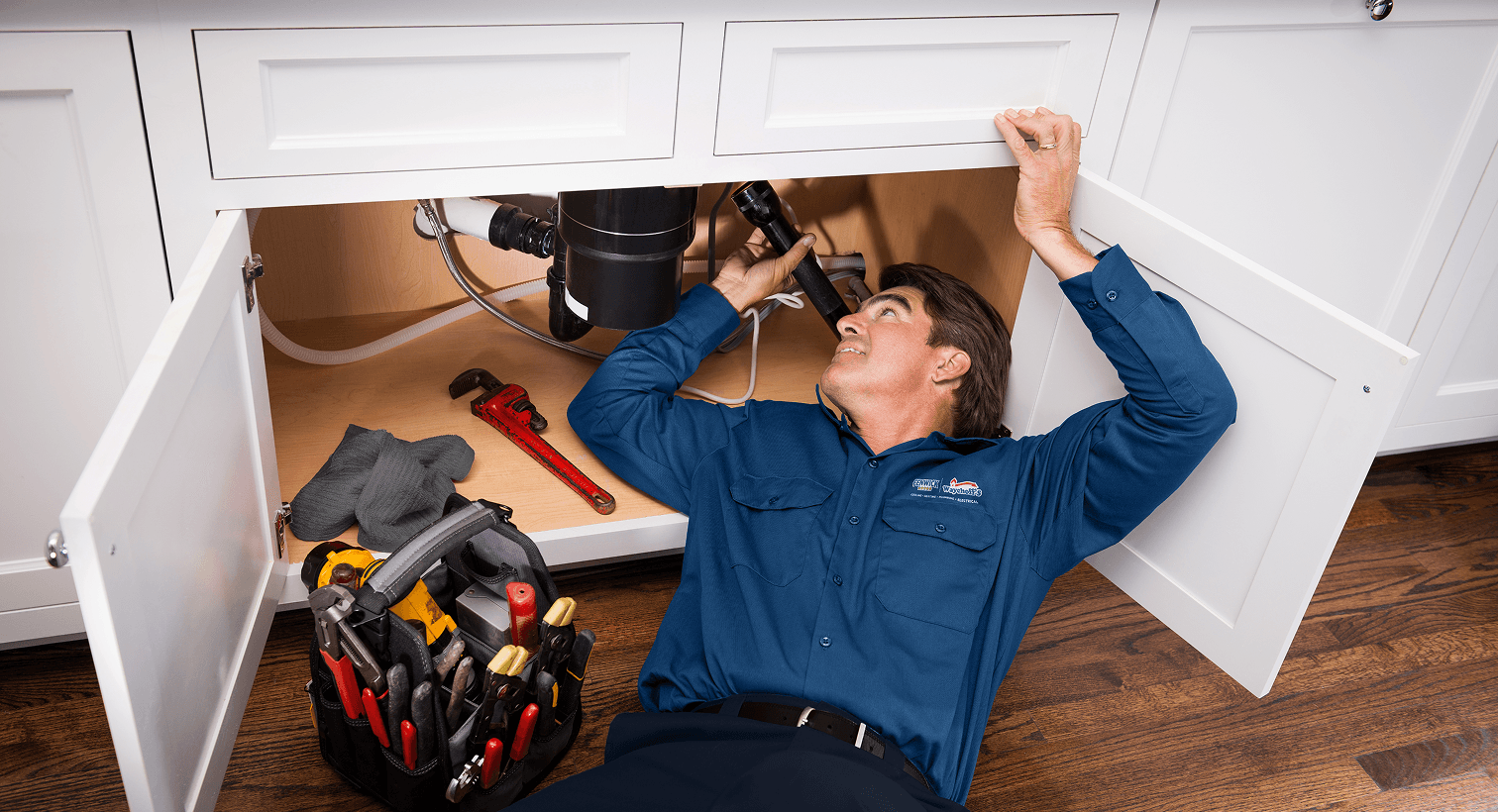Tech inspecting under sink